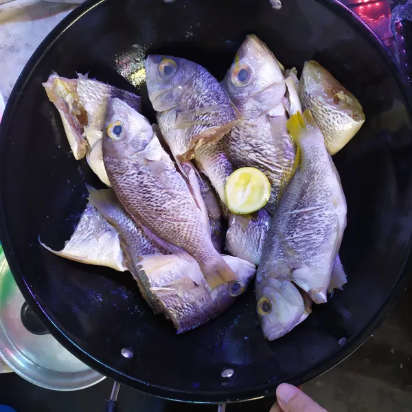 Bersihkan ikan, cuci lalu beri perasan jeruk nipis dan garam, aduk rata.