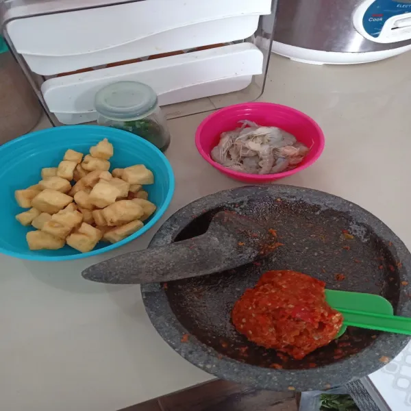 Siapkan bahan yang akan digunakan, lalu uleg bumbu halus. Goreng tahu sebentar, lalu tiriskan.