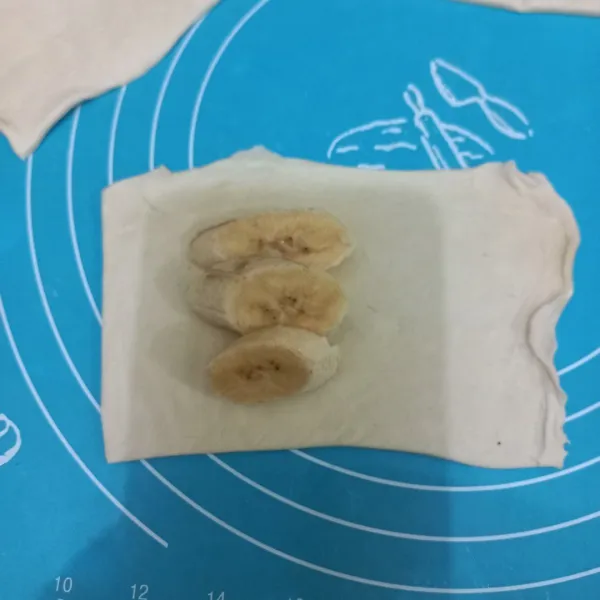 Tata potongan pisang di atas kulit pastry.