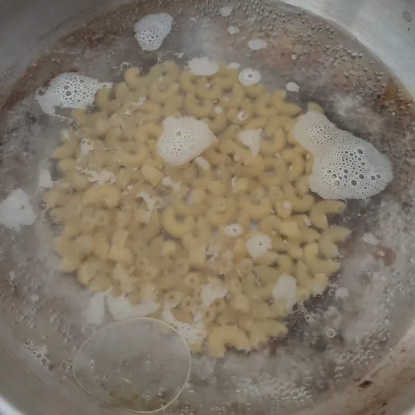 Rebus makaroni dalam air mendidih dan sedikit minyak hingga empuk, lalu tiriskan.