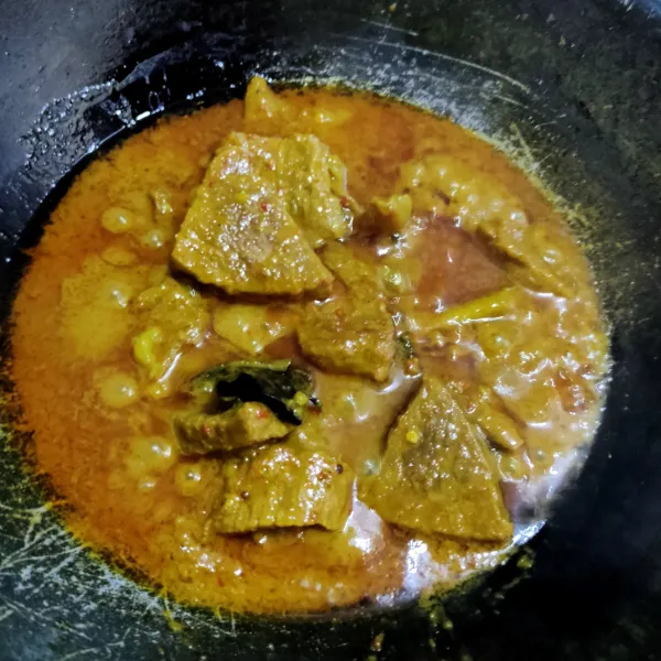 Jika daging sudah empuk dan air tinggal sedikit, koreksi rasa.
Pada tahapan ini rendang harus sering diaduk hingga air benar- benar surut dan bumbu berubah warna kecokelatan.
Angkat dan sajikan.