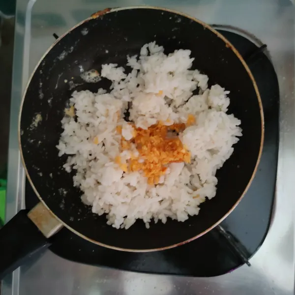 Masak nasi, minyak bawang putih, dan kaldu bubuk, kemudian campurkan.