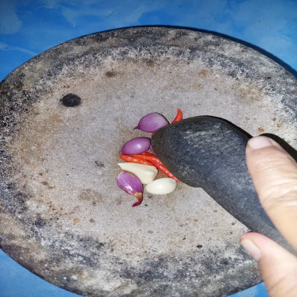 Campur cabe, bawang merah dan bawang putih, lalu ulek hingga halus.