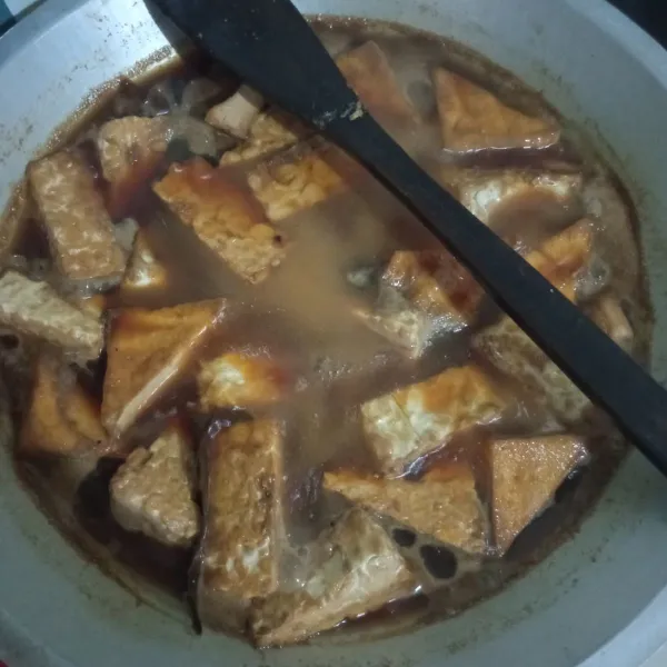 Nyalakan kompor, pastikan tempe dan tahu terendam. Masak dengan api kecil saja.