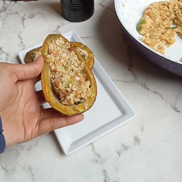 Kerok bagian daging ubi sehingga menyerupai mangkuk, lalu masukkan tahu ke dalam ubi tersebut.