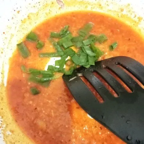 Setelah bumbu mengental, tambahkan irisan daun bawang. Masak sebentar lagi, kemudian matikan api.
