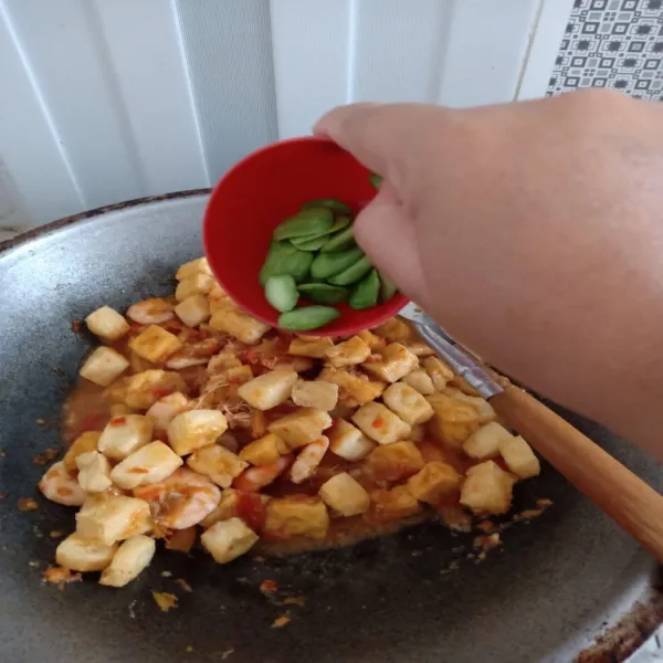 Saat air mulai berkurang, lalu masukkan petai dan aduk rata kembali.