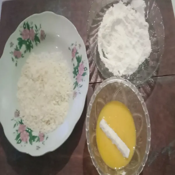 Baluri tempe ke tepung terigu yang sudah dicampur kaldu bubuk, kemudian celupkan ke dalam telur yang sudah dikocok. Setelah itu balur ke dalam tepung roti sambil dikepal-kepal supaya tepung roti menempel.