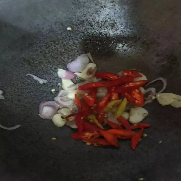 Masukkan cabe rawit dan cabe keriting, tumis hingga setengah layu.
