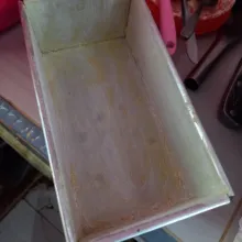 Siapkan loyang brownies, lalu olesi margarin dan taburi merata dengan tepung terigu.