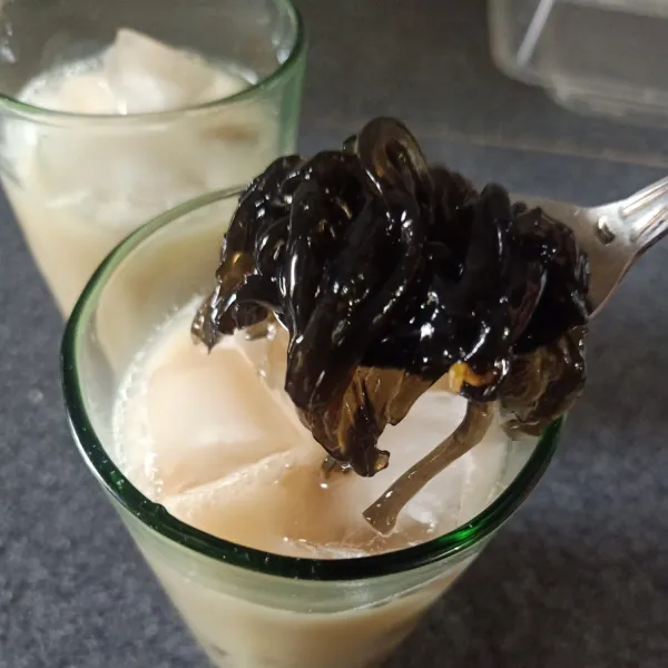 Tuang Es batu ke dalam gelas saji, lalu tuang teh susu, masukan cincau. Sajikan.