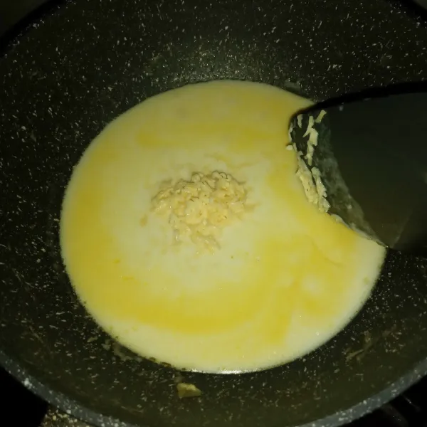 Buat saus putih, panaskan butter, masukkan tepung terigu, aduk cepat sampai menggumpal. 
Tuang susu sambil diaduk terus. 
Tambahkan garam, lada dan keju parut, aduk sampai keju larut. 
Matikan api.