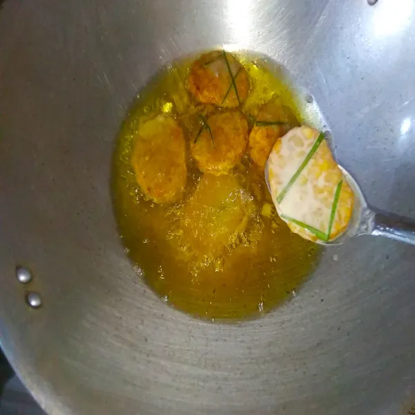 Masukkan tempe pada minyak yang sudah dipanaskan terlebih dahulu. Goreng hingga matang berwarna kuning kecokelatan. Lalu angkat dan tiriskan, kemudian sajikan selagi hangat.