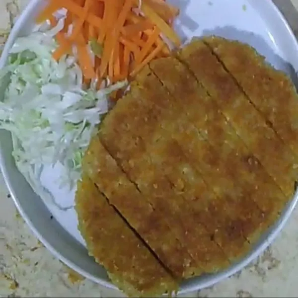 Sajikan tofu katsu bersama irisan wortel dan kol.