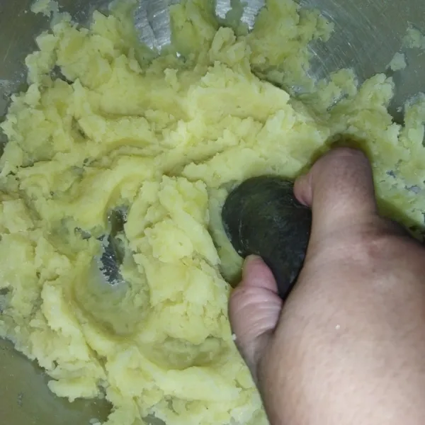 Selagi panas, haluskan kentang dengan cara ditumbuk atau dihaluskan dengan menggunakan garpu.