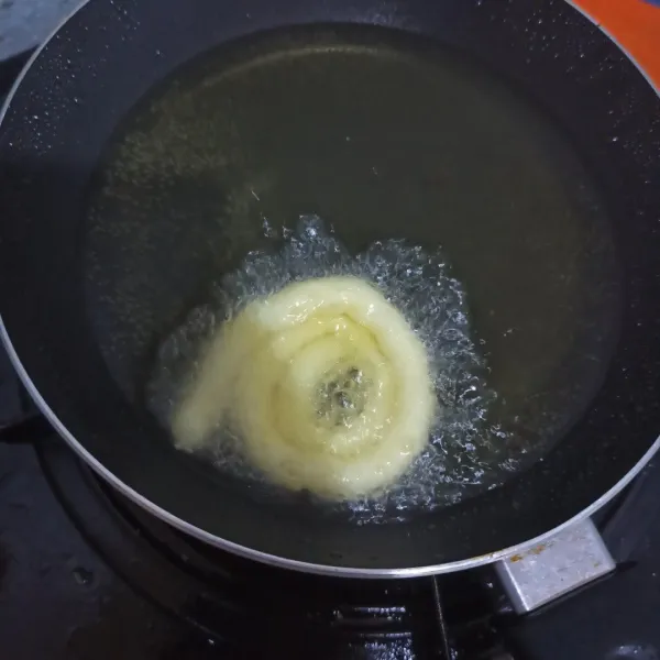 Panaskan teflon, tekan melingkar kentang yang ada di piping bag di atas minyak panas seperti di gambar. 
Kemudian goreng hingga kering. 
Setelah itu angkat, tiriskan.