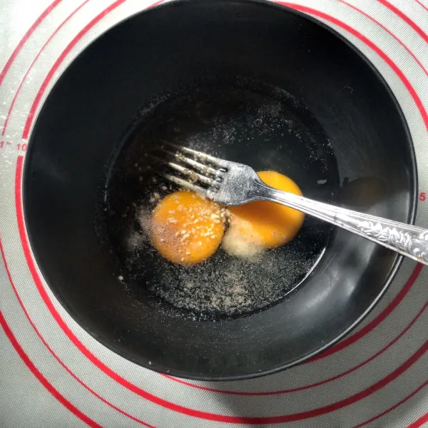 Kocok telur bersama dengan garam, kaldu jamur dan lada.
