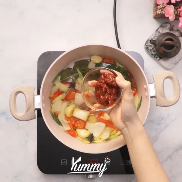 Tambahkan saus kacang pedas, daging sapi dan tomat. Kemudian masukkan gula palem, kecap hitam, dan kecap asin, lalu aduk hingga merata.