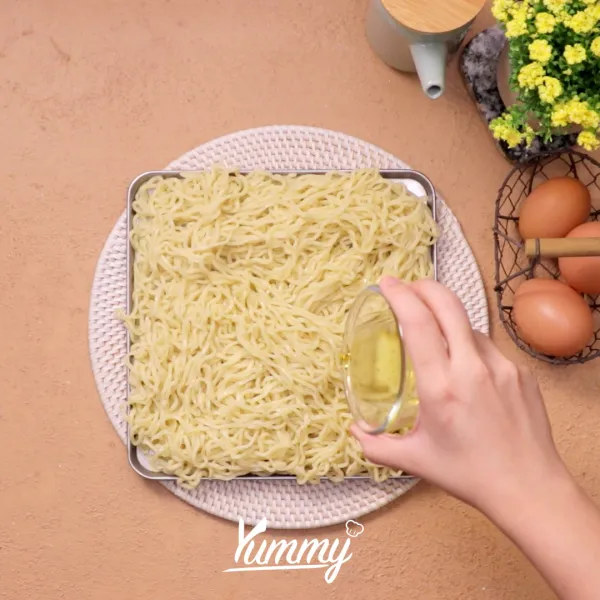 Tuang sedikit minyak yang sudah dipanaskan agar mie tidak menggumpal.