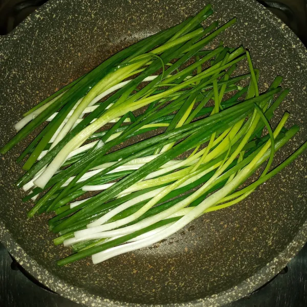 Celupkan kuas ke minyak lalu oleskan kewajan anti lengket (ini bertujuan agar penggunaan minyak tidak berlebihan). Nyalakan api kecil tata daun bawang diwajan dan tutup wajannya.