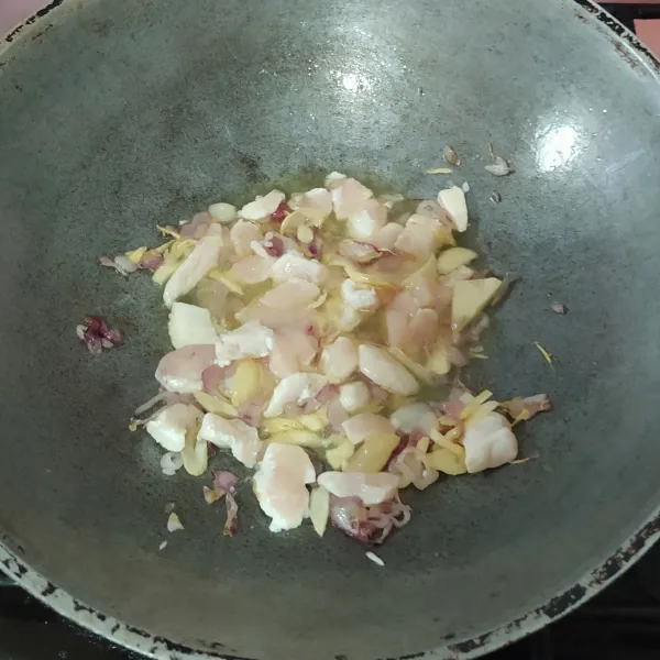 Tumis bawang merah dan bawang putih hingga harum, lalu masukkan ayam.