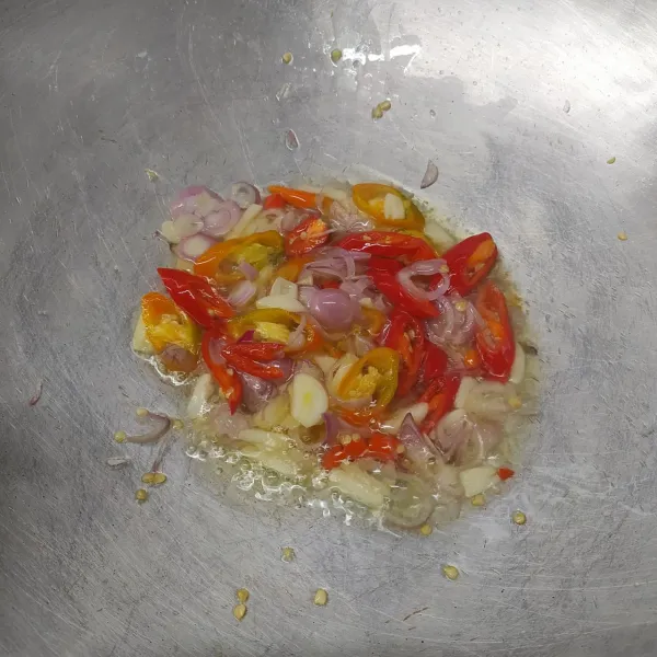 Tumis bawang merah, bawang putih, cabe merah dan cabe rawit, sampai layu dan harum.