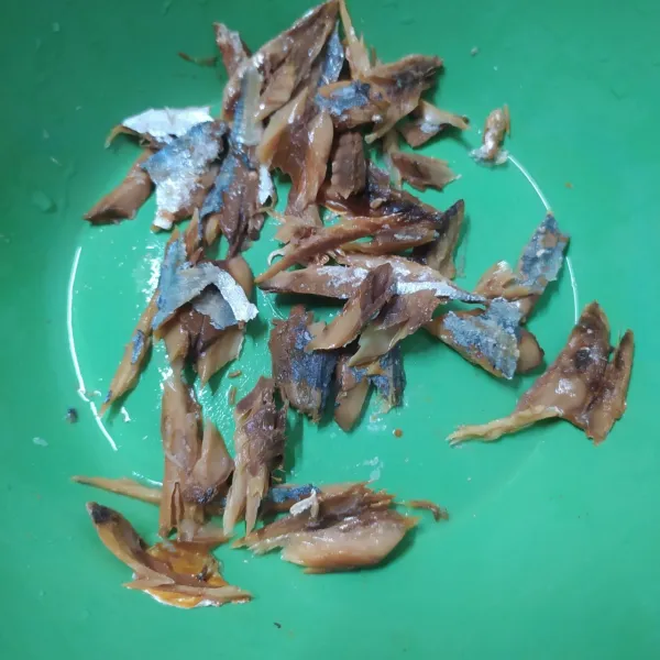 Rendam ikan asin peda dalam air panas. Jika sudah lunak, suwir-suwir daging ikan asin peda. Sisihkan.