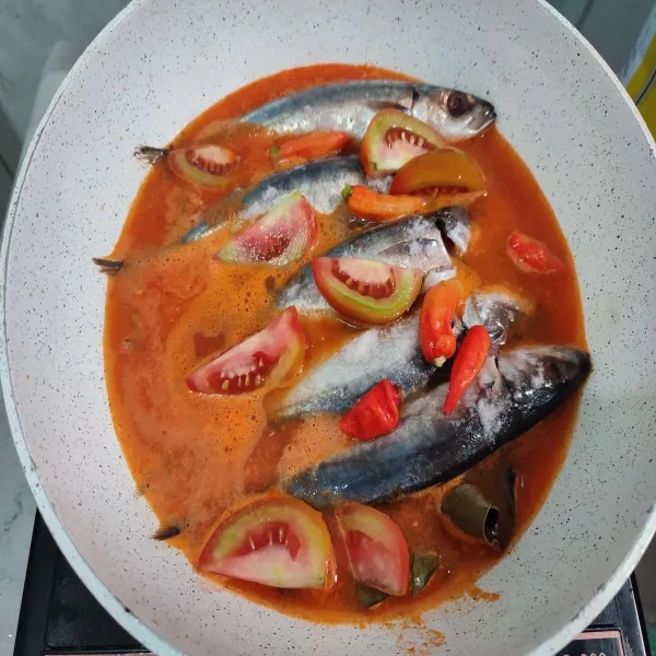 Jika ikan sudah mulai matang, masukkan tomat dan cabai rawit. 
Cek rasanya, jika masih kurang asin, tambahkan lagi garam.