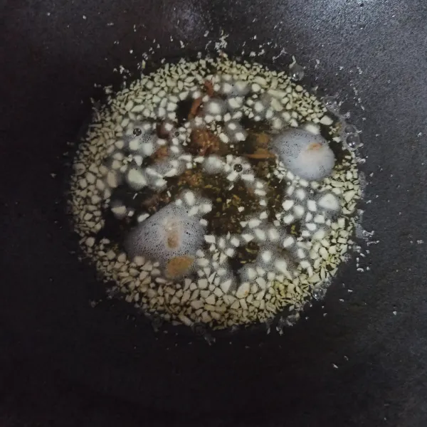 Panaskan minyak sisa menggoreng kulit ayam  Masukkan jahe iris dan bawang putih sedikit demi sedikit ke minyak.