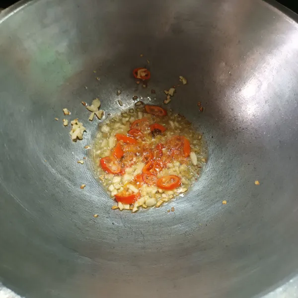 Panaskan minyak goreng lalu tumis bawang putih dan cabe sampai harum.