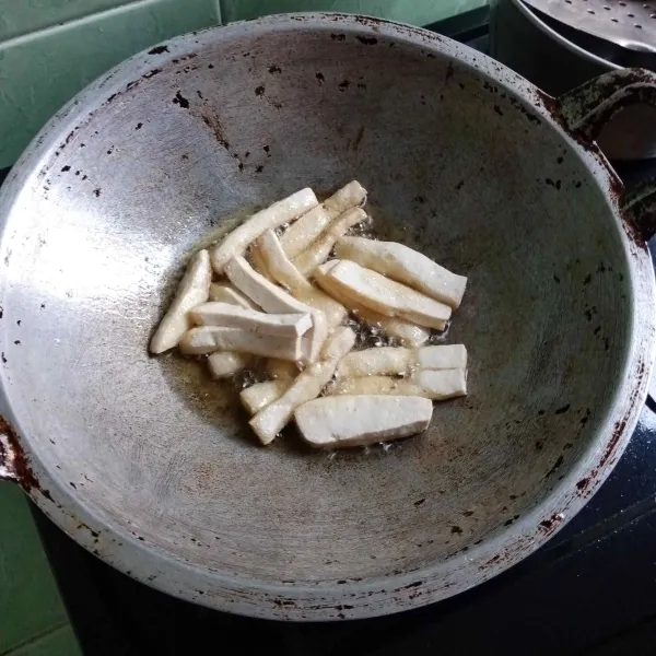 Potong tahu memanjang, lalu goreng hingga berkulit dan tiriskan.