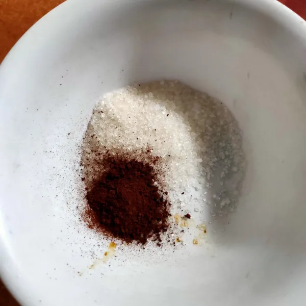 Masukkan gula pasir, kopi dan air panas ke dalam mangkuk.