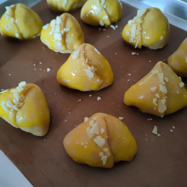 Lakukan berulang hingga habis, kemudian olesi dengan kuning telur dan beri hiasan almond cacah.