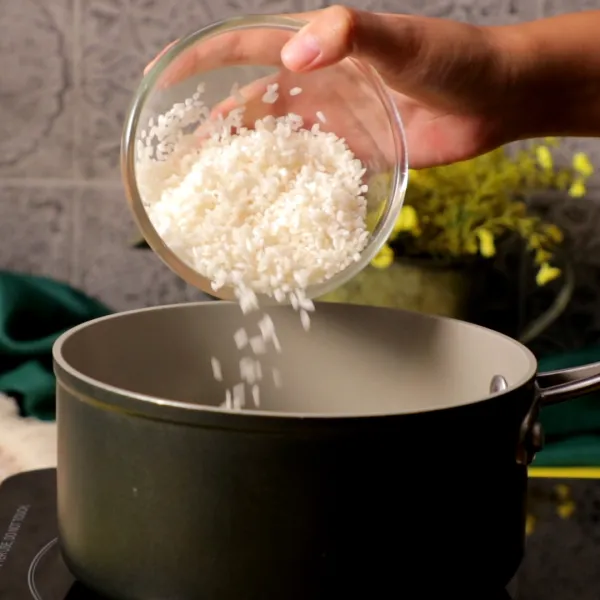 Masukkan beras yang telah dicuci sebelumnya ke dalam panci. Tambahkan air dan masak hingga air menyusut kurang lebih 10 menit.