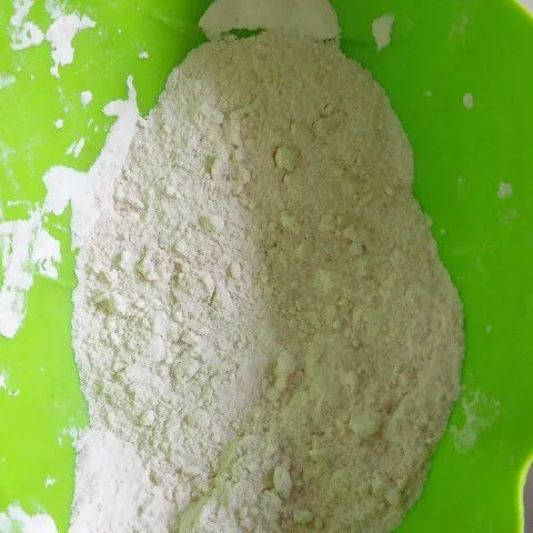 Siapkan 2 bungkus tepung bumbu Sasa serbaguna kedalam wadah dan ambil baluri ayam yang sudah diambil darı lemari es kedalam adonan tepung kering.