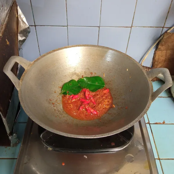 Lalu masukkan irisan cabe merah dan daun jeruk, aduk.