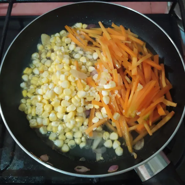 Masukkan jagung dan wortel, tuang air dan aduk rata.