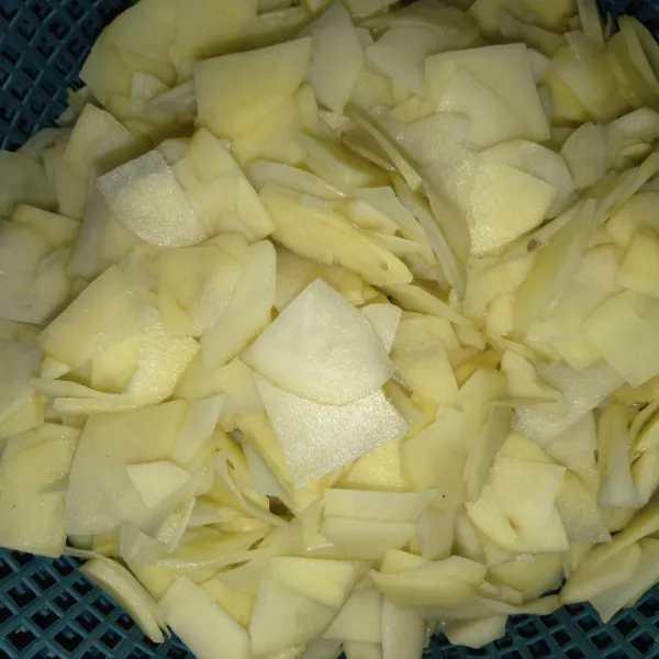Kupas kentang potong dan iris tipis. Cuci beberapa kali hingga airnya bening. Tiriskan dan goreng hingga renyah