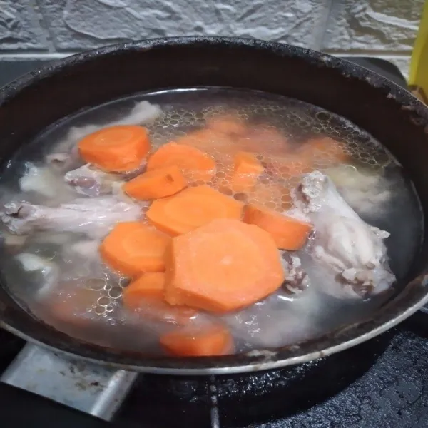 Masukkan irisan wortel, masak hingga wortel mulai empuk.