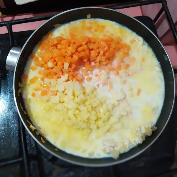 Masukkan wortel, kentang, kaldu ayam, susu cair dan krimer kental manis.