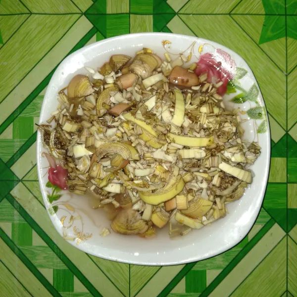 Iris jantung pisang, rendam dengan air garam sebentar saja agar warna tidak hitam.