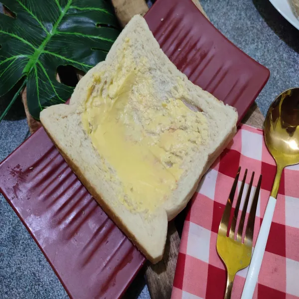 Tumpuk 2 roti tawar, lalu olesi bagian atasnya dengan margarin.
