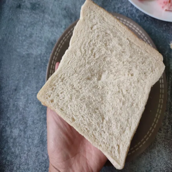 Tangkupkan 2 slice roti tawar sehingga bagian isinya ada di tengah.