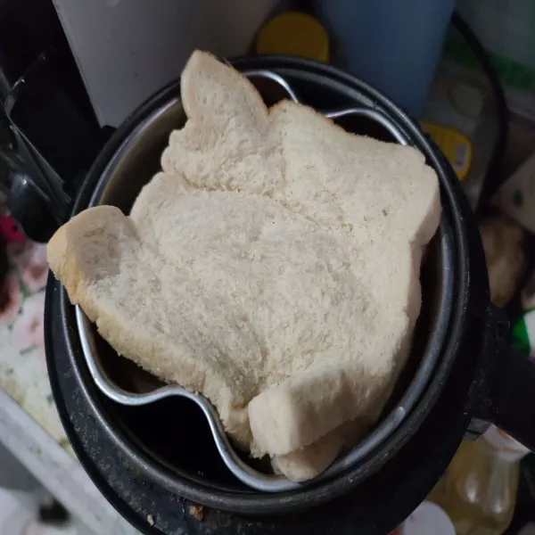 Didihkan air di dalam rice cooker, lalu kukus roti selama 10 menit.