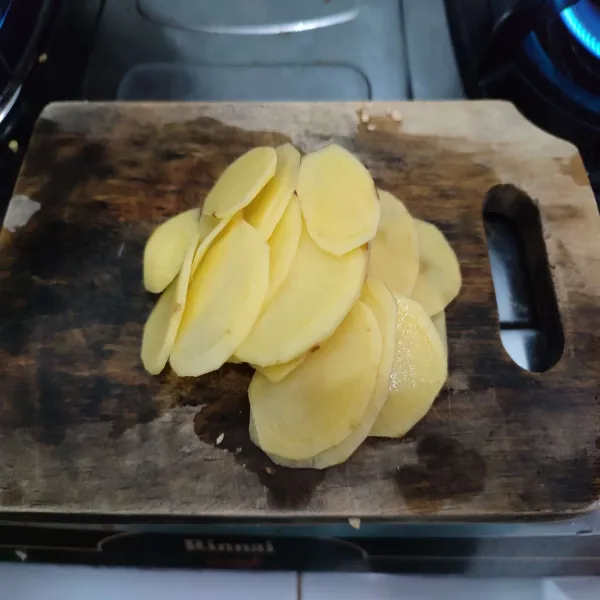 Potong tipis kentang, kemudian baluri dengan sedikit garam.