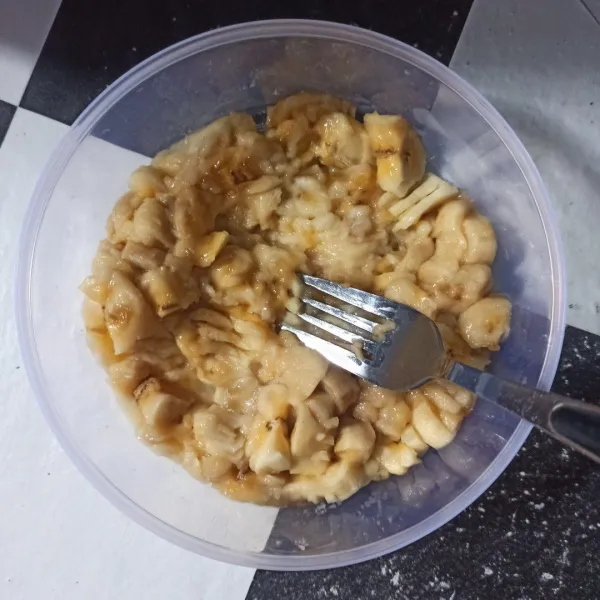 Kupas pisang lalu hancurkan dengan garpu.