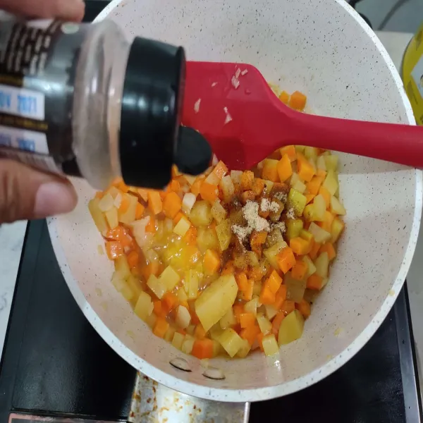 Kemudian bumbui dengan kaldu bubuk, merica serta garam. 
Tambahkan sedikit air agar kentang dan wortel cepat empuk.