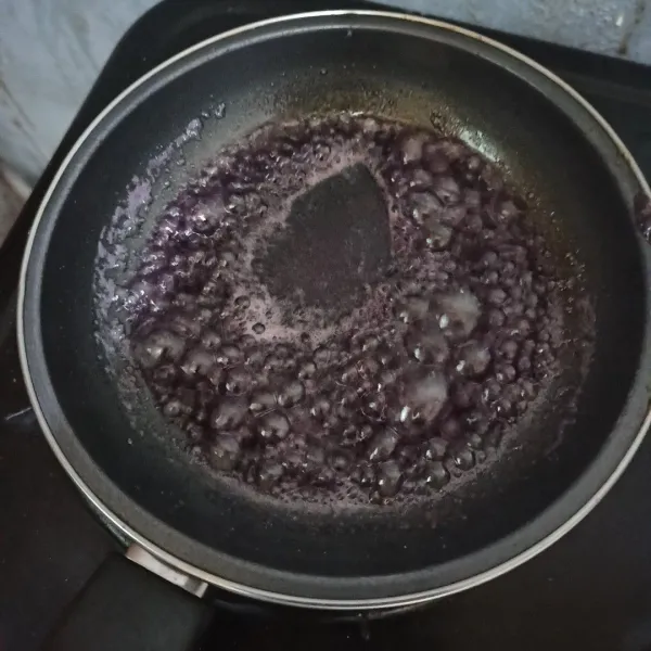 Siapkan teflon, masukkan gula, air, lelehkan gula pasir. 
Kemudian beri pewarna ungu, aduk rata.