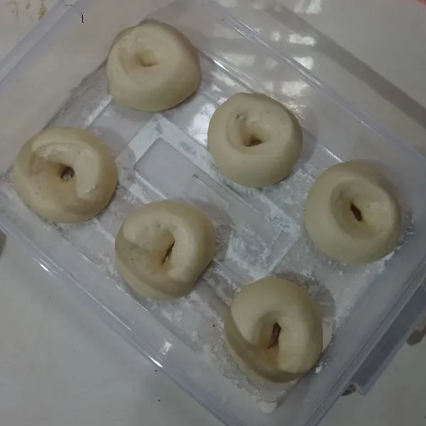 Timbang adonan dengan berat 45 gr, bulatkan dan pipihkan lalu buat lubang di bagian tengah adonan.
Diamkan selama 45 menit atau sampai mengembang 2 kali lipat.