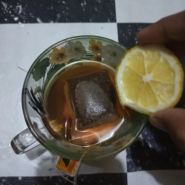 Beri perasan jeruk lemon ke dalam teh.